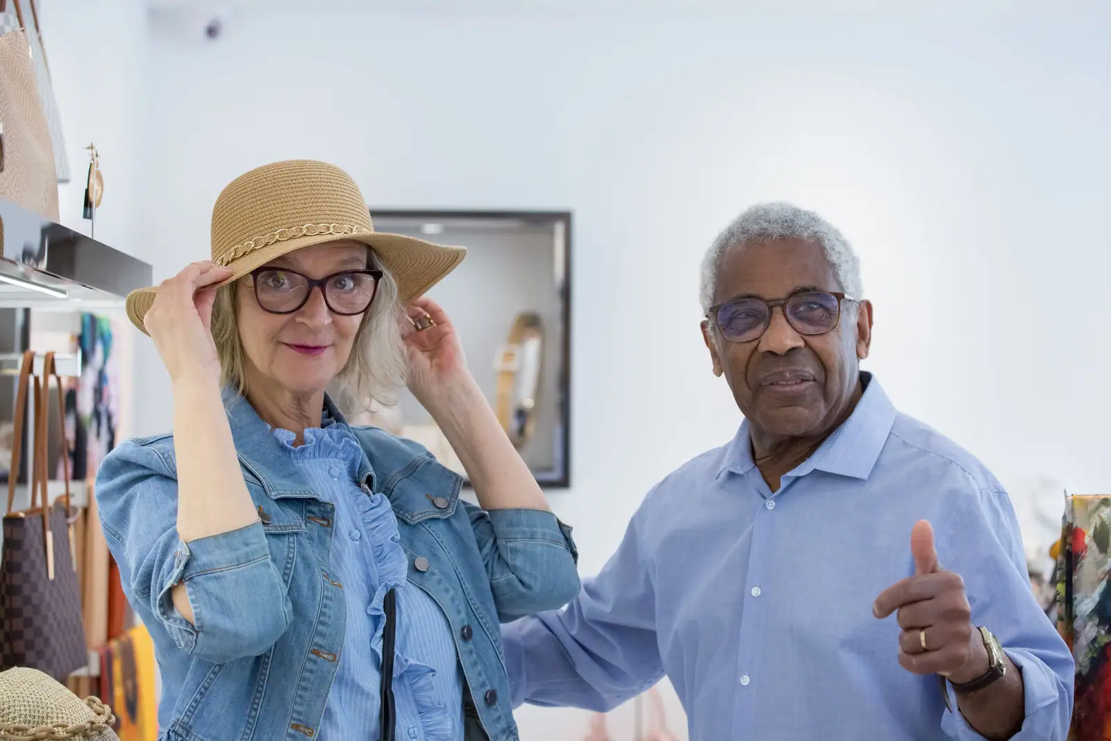 A couple trying on hats in a shop on the square