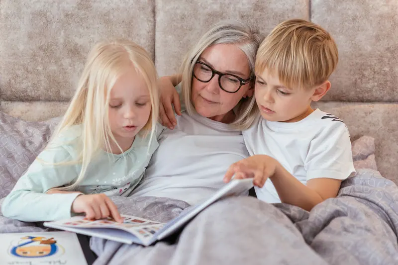 A grandmother reading to the grandchildren