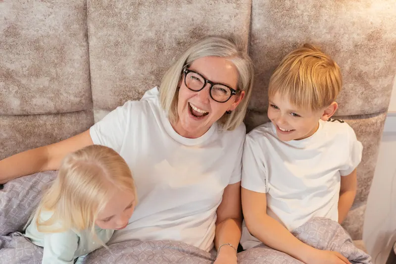 A grandmother laughing with her grandchildren
