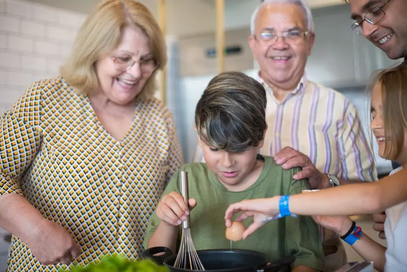 Grandparents baking with their grandchildren in the family kitchen