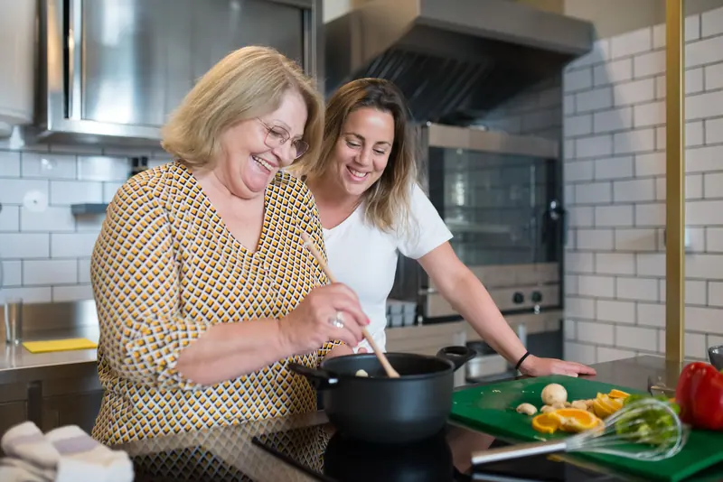 A mother and daughter cooking together