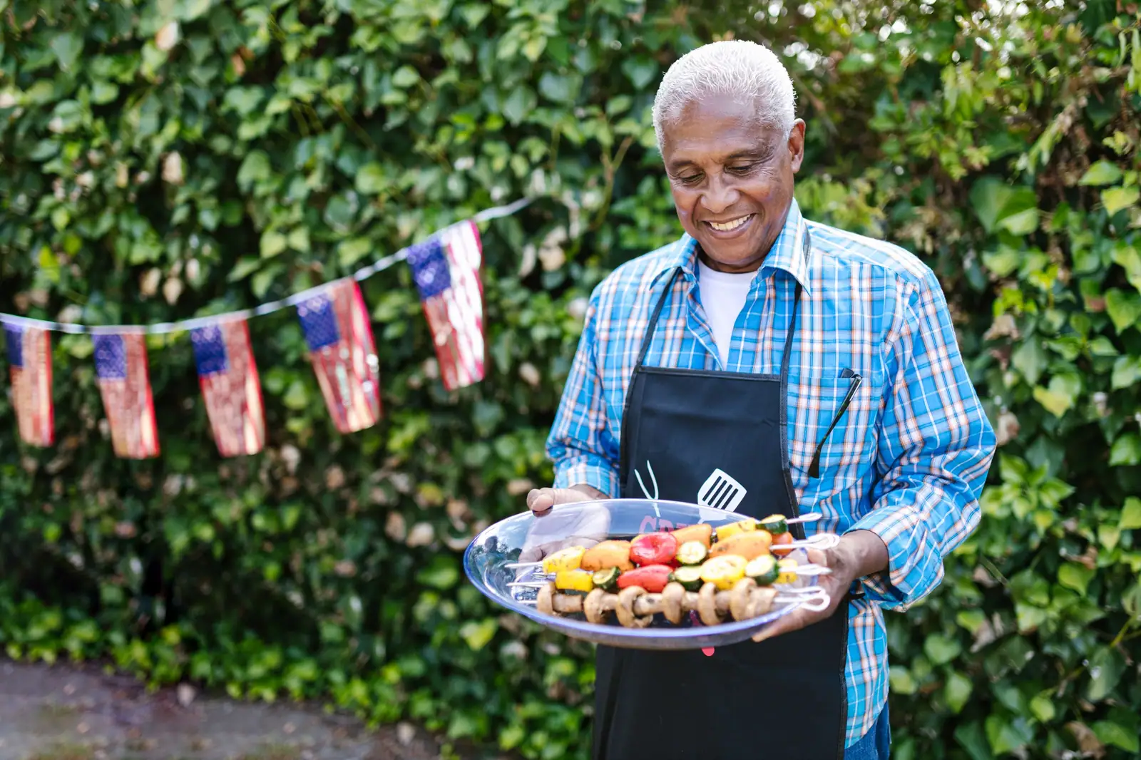 A resident holding a platter of grilled vegetables