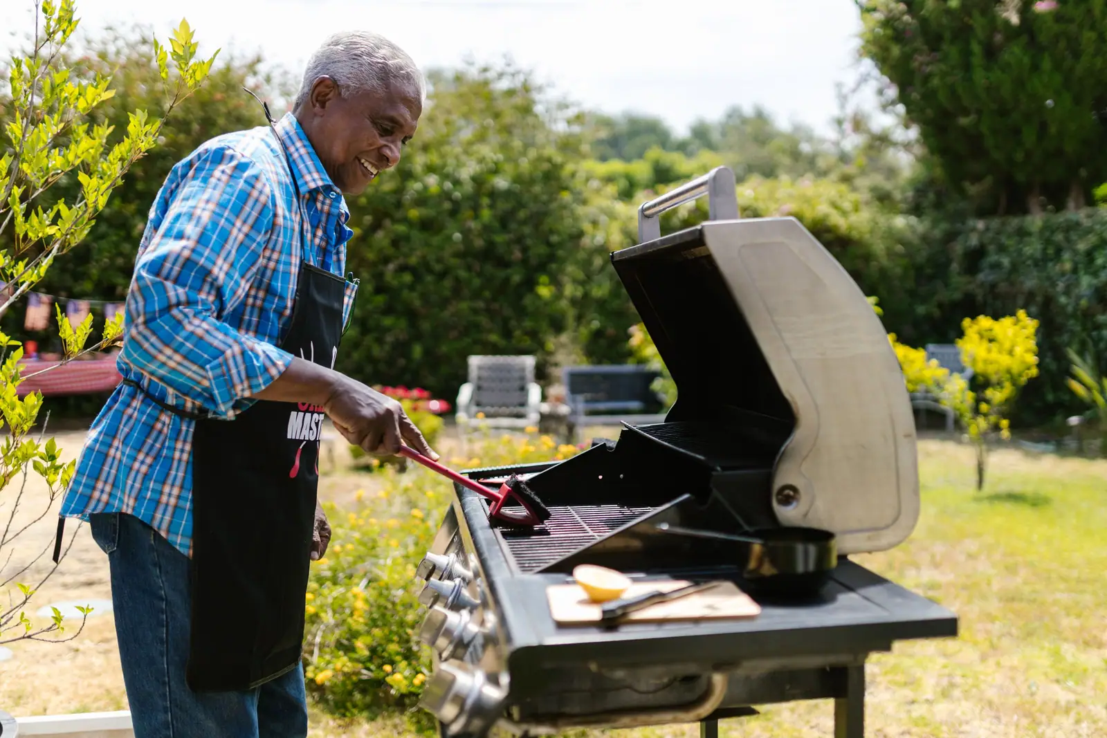 A resident tending the grill in the yard
