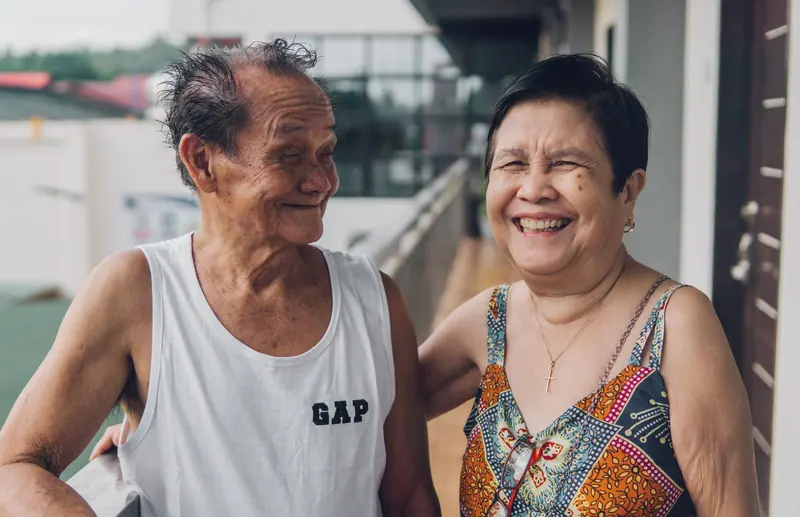 A couple laughing on their cottage porch