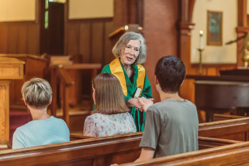The pastor greeting residents after the service