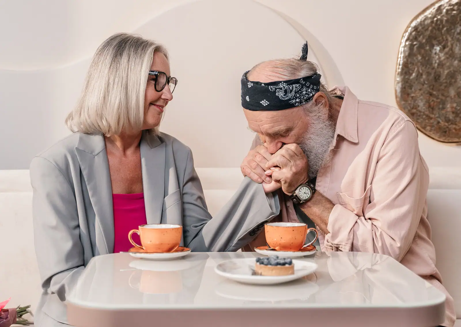A husband and wife leaning close over coffee and pastries in the Lane Café