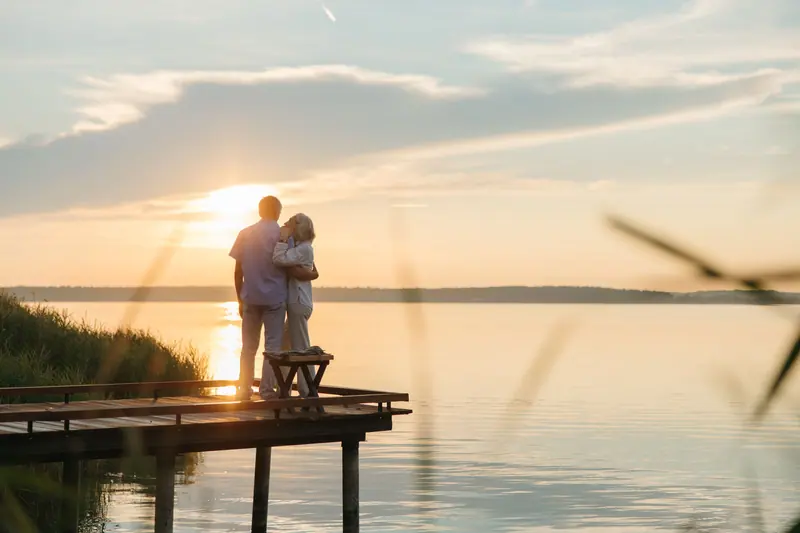 A couple embracing on the dock at sunset