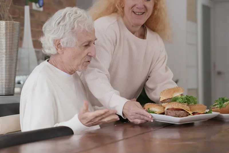 A couple sharing burgers at home