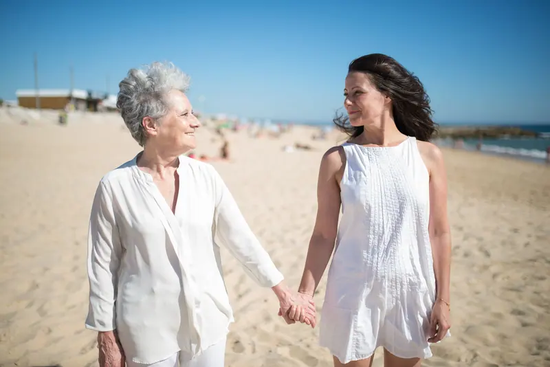 A mother and daughter walking the beach