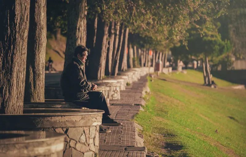 A resident resting on a shaded bench