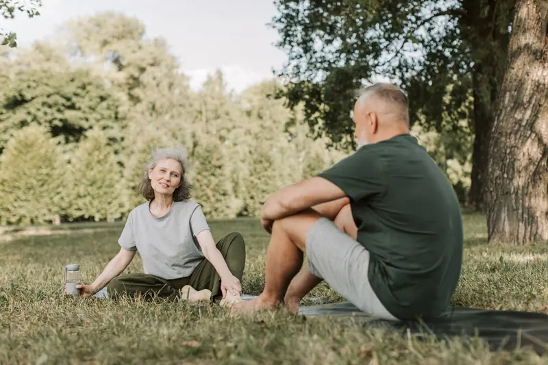 A couple practicing yoga in the sun
