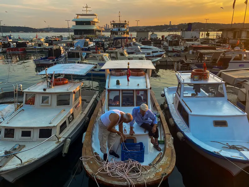 Two friends working on a fishing boat at the marina