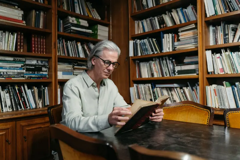 A resident reading at the long library table