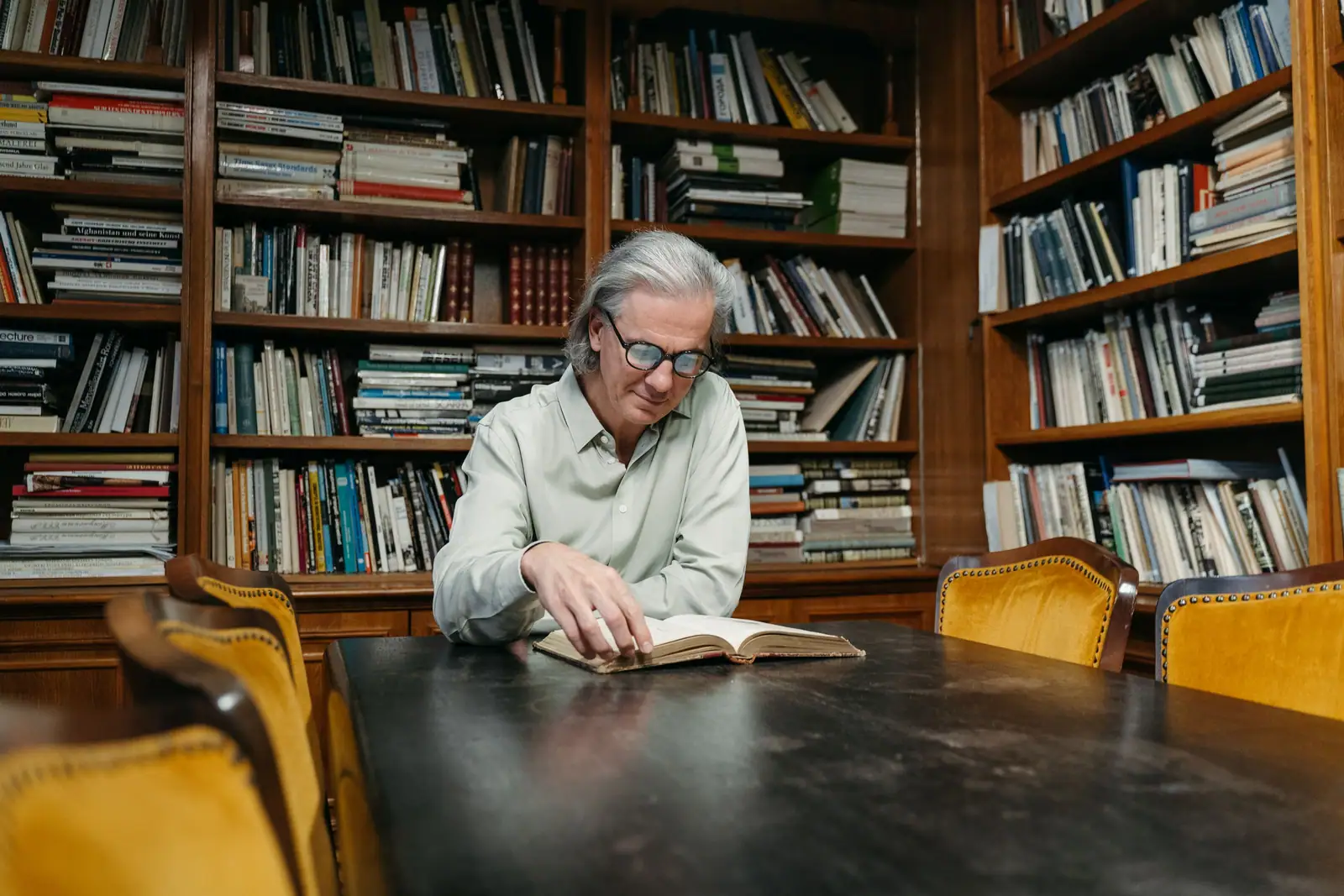 A resident reading at the long table in the library