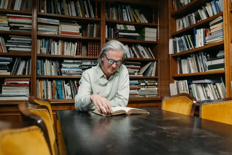 A resident reading at the long table in the library