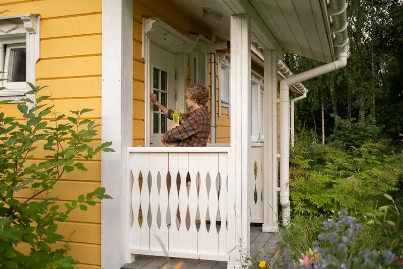 A resident on the porch of the garden cottage