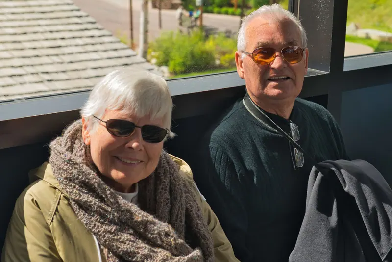 A couple bundled up on the patio, smiling