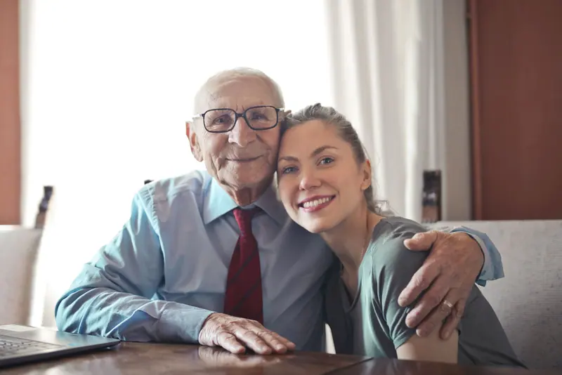 A resident with his arm around his granddaughter