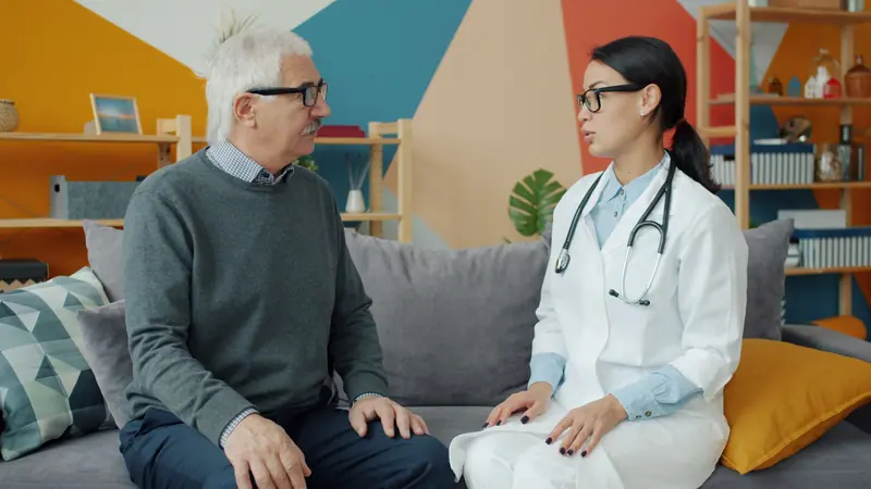 The nurse practitioner talking with a resident in the lounge