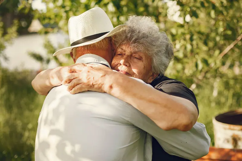 Two residents hugging on the garden walk