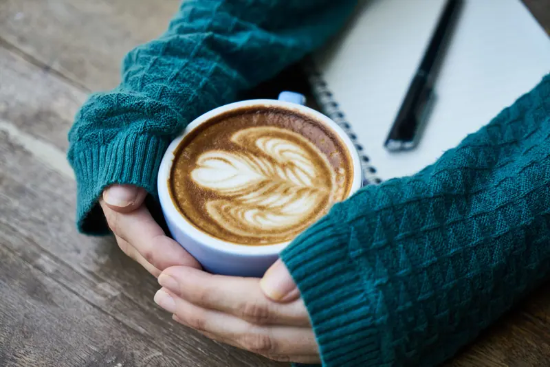 A cup of coffee in a resident's hands