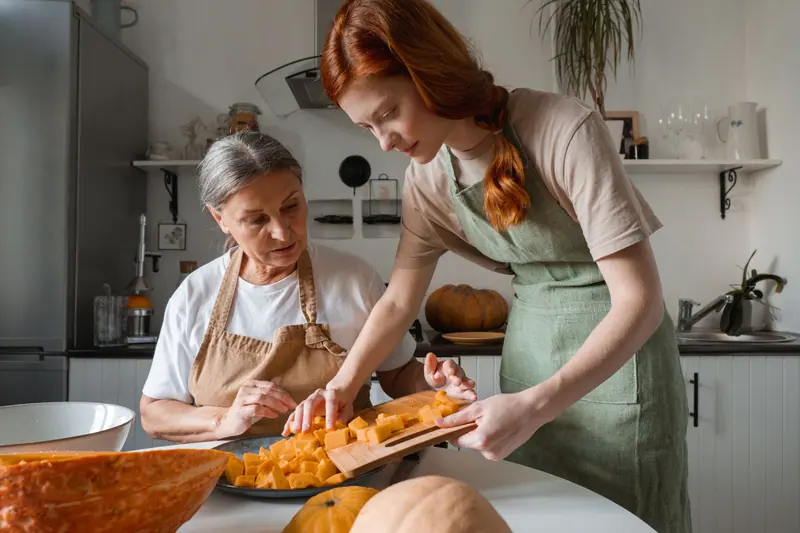 An older woman cooking with her granddaughter