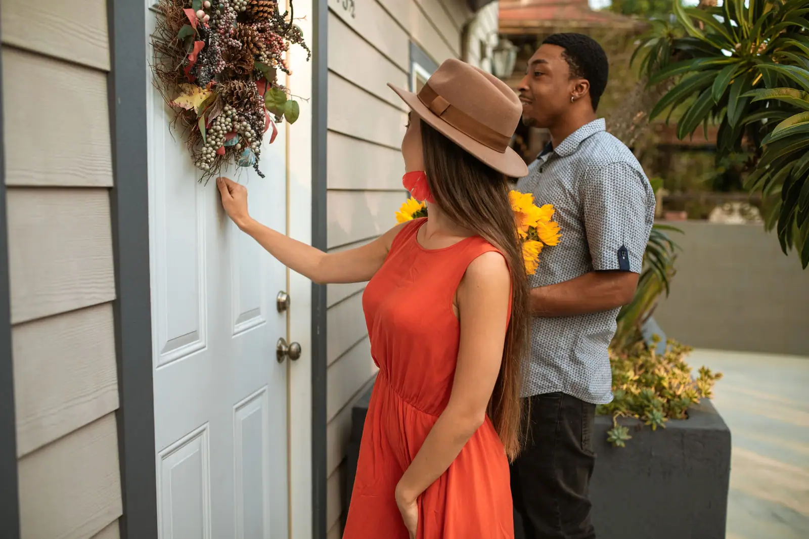 Visitors with flowers knocking at a front door