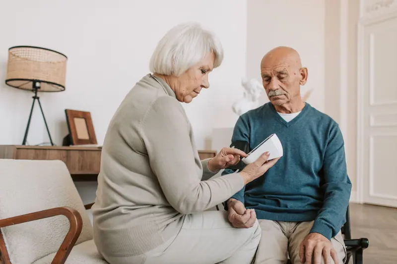 An older woman going over her husband's health log with him
