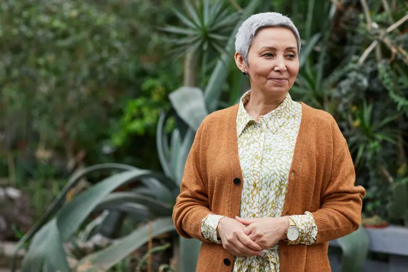 A resident in the garden in her rust cardigan