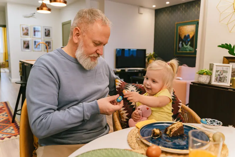A resident sharing his lunch with his baby granddaughter