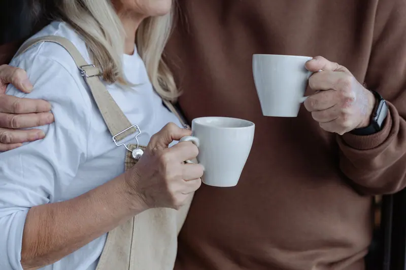 An older couple sharing coffee in their sitting room