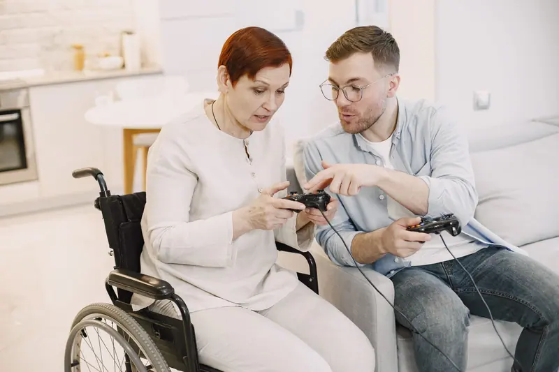 A woman in a wheelchair playing video games with her son