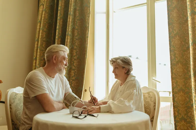 An older couple writing down blood-pressure readings at the table