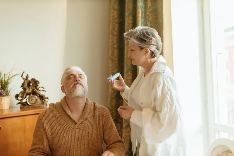 An older woman giving her husband eye drops