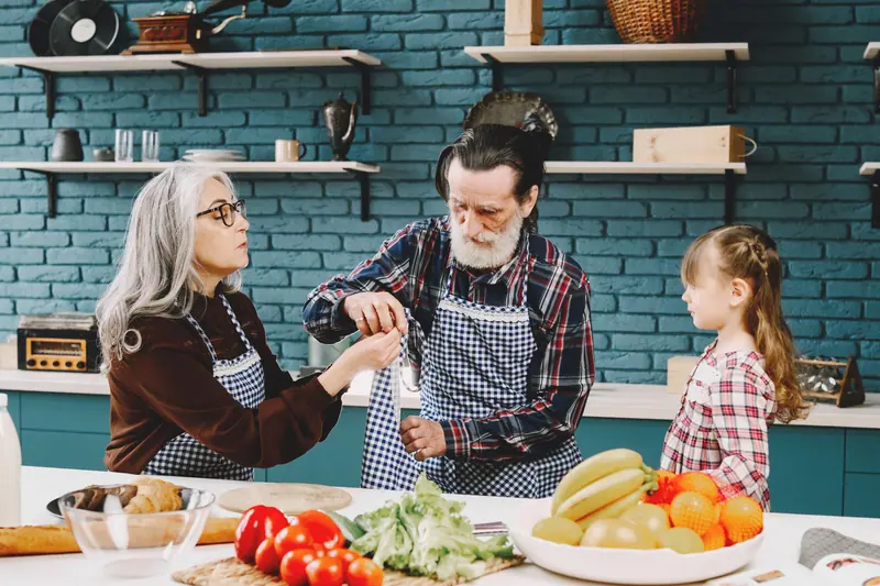 Grandparents cooking with their granddaughter