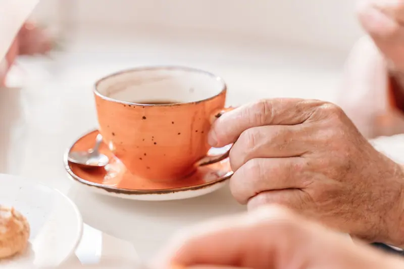 An orange teacup in a resident's hands at the end of the day