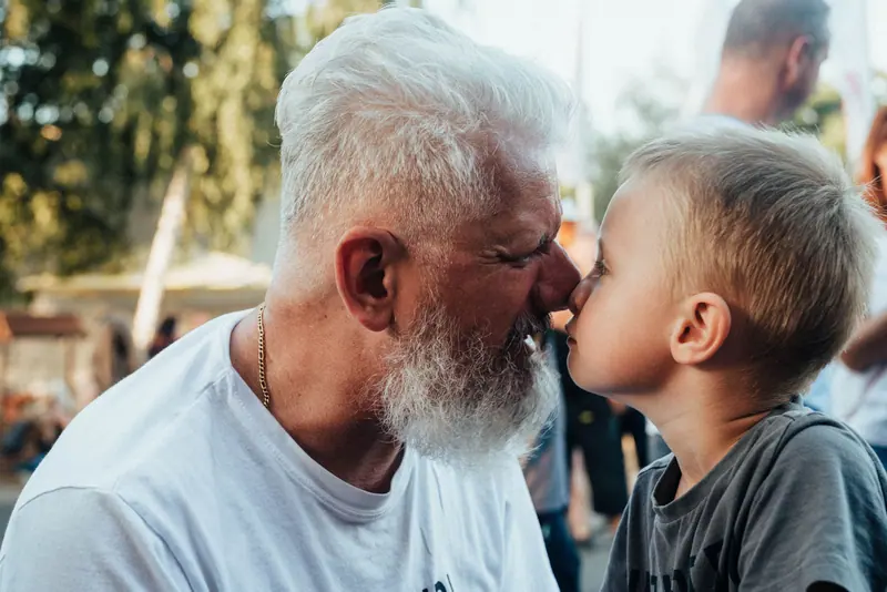 A grandfather and grandson touching noses