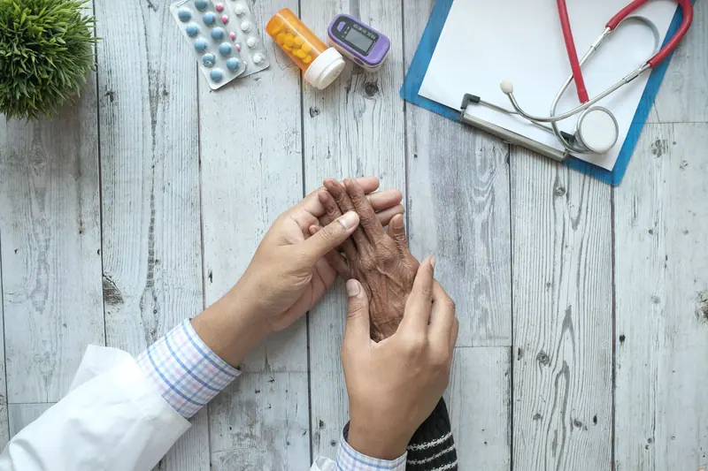 A doctor holding a patient's hands across the table