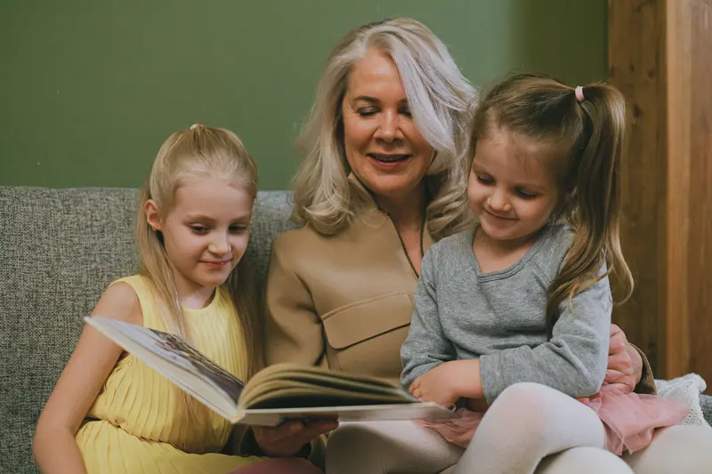 A grandmother reading with her granddaughters