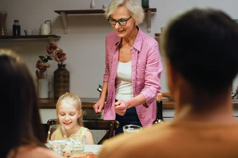 A grandmother serving supper to her family