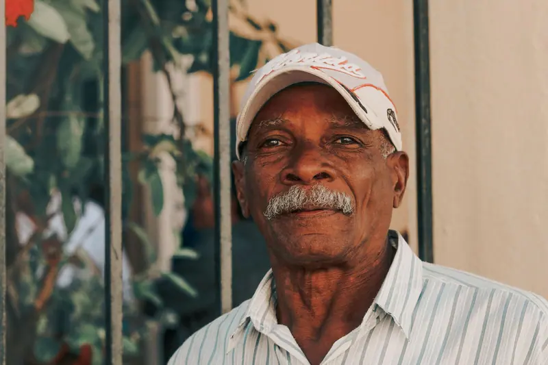 A man in a ball cap smiling outdoors
