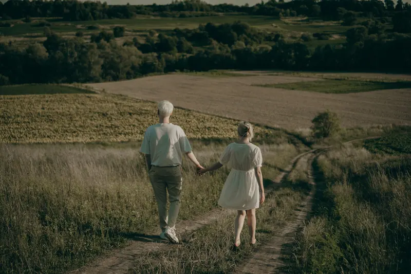 An older couple walking a country lane