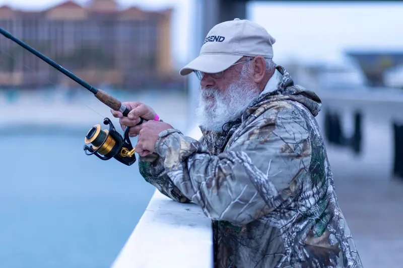 A grandfather fishing from the pier