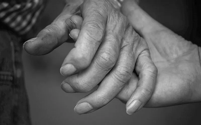 An elderly couple's hands, in black and white