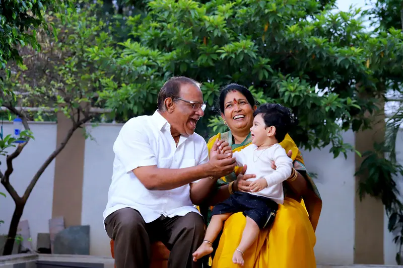 Grandparents laughing with their grandbaby in the garden