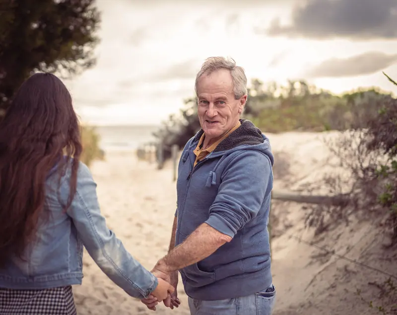 A daughter walking her father down to the shore