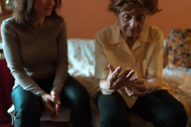 A chaplain listening as a patient talks with her hands