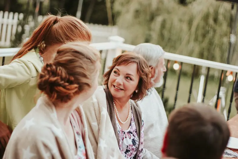 A grandmother smiling at a summer gathering