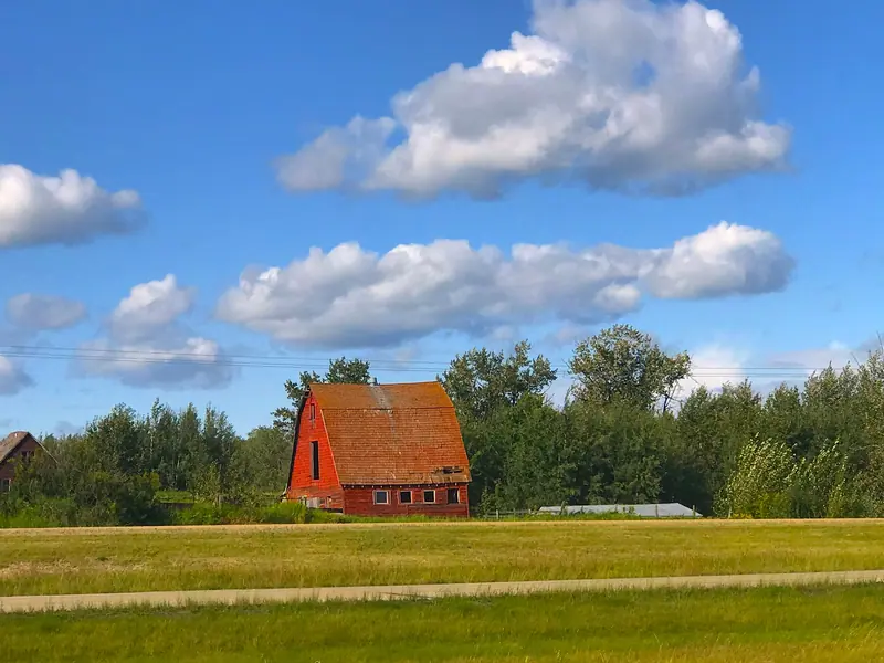 A red barn under a bright blue sky