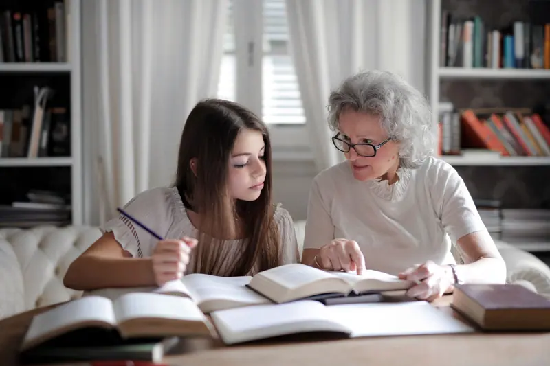 A grandmother helping her granddaughter with homework